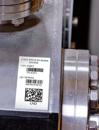 A manufacturing machine is marked by an asset management barcode label