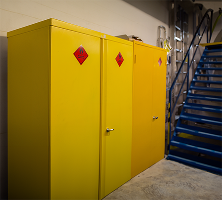Industrial flammable storage cabinets labeled with hazard symbols, meeting OSHA labeling requirements for safety.