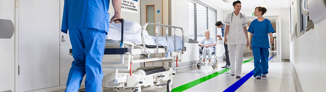 A hospital hallway with floor marking and OSHA signage