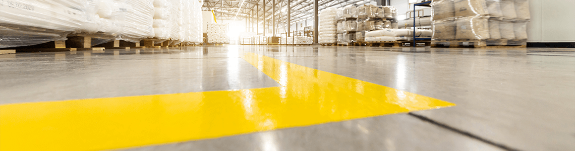 Yellow floor marking tape on a warehouse facility floor