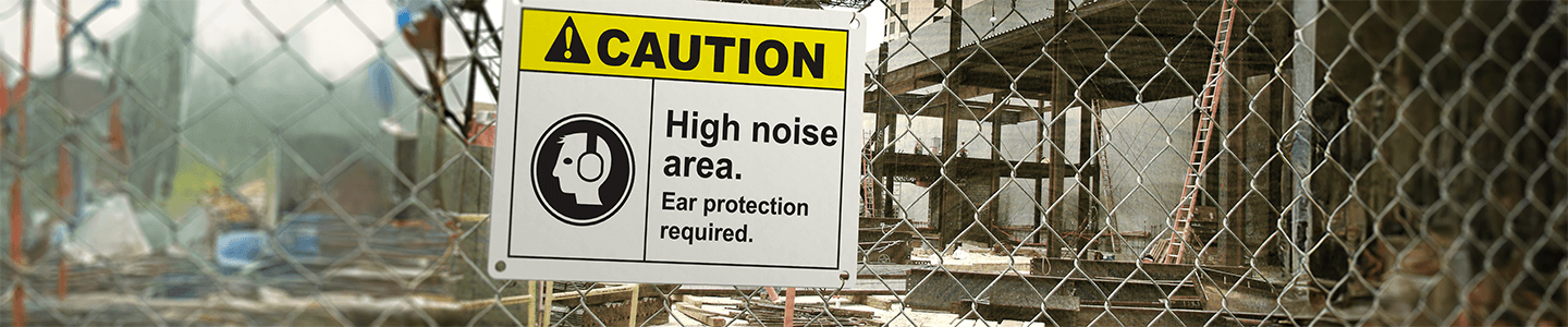 Caution: High Noise Area sign displayed on a fence at a jobsite.
