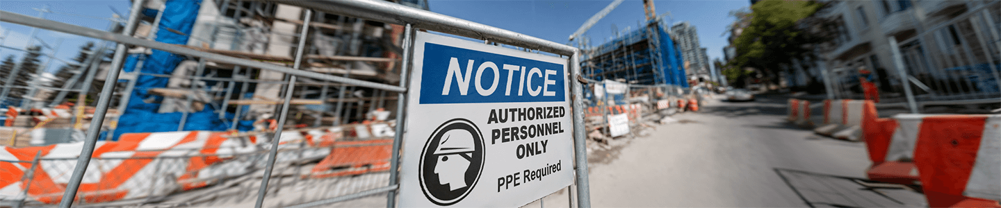 Construction safety sign reading 'Authorized Personnel Only—PPE Required' at job site entrance.
