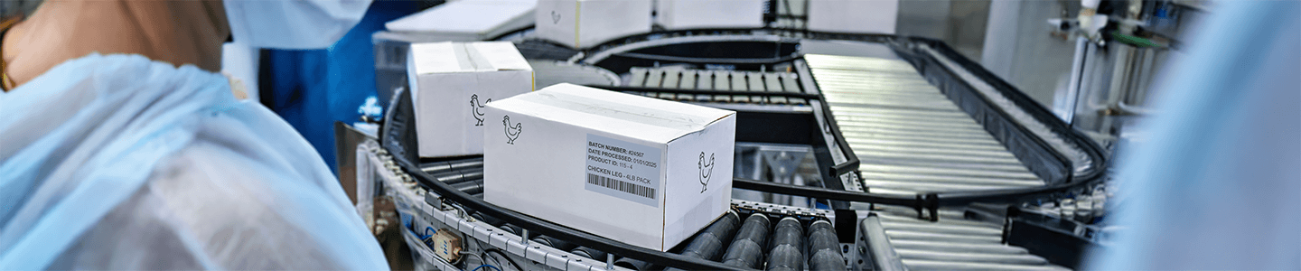 Packages of food in boxes traveling down a conveyor belt.