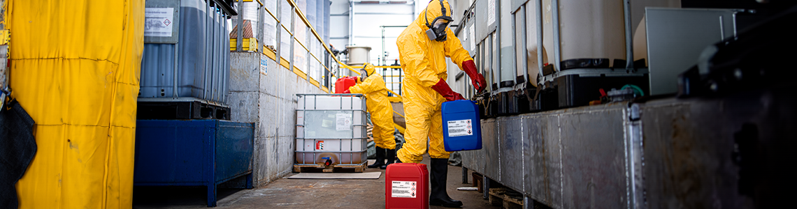 Workers handling chemical containers clearly marked with outdoor labels.