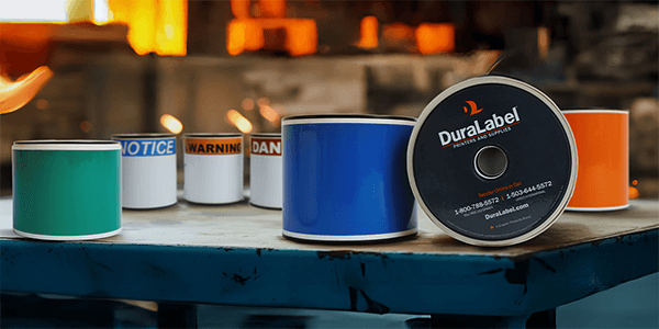 DuraLabel supply rolls with notice, warning, and danger stock on a workbench.