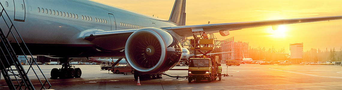 An airplane on a runway with workers