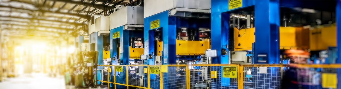 Manufacturing facility with large machines that are marked with clear safety signs and labels.