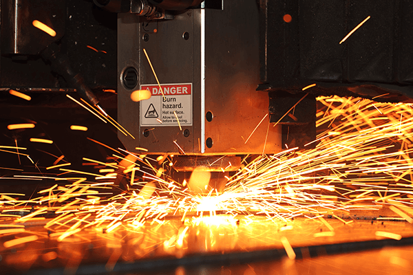 Industrial manufacturing equipment labeled with a Danger: Burn Hazard Premium Vinyl Label