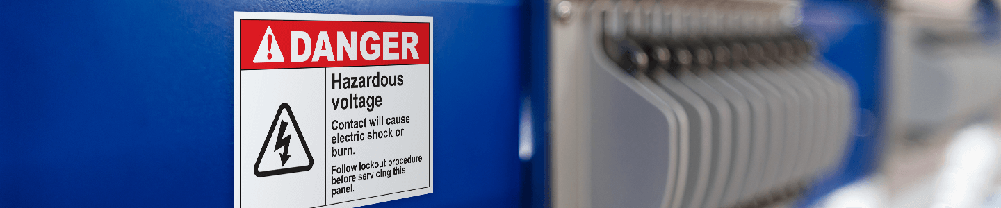 A Danger: Hazardous Voltage Premium Vinyl Label pictured on a piece of equipment.