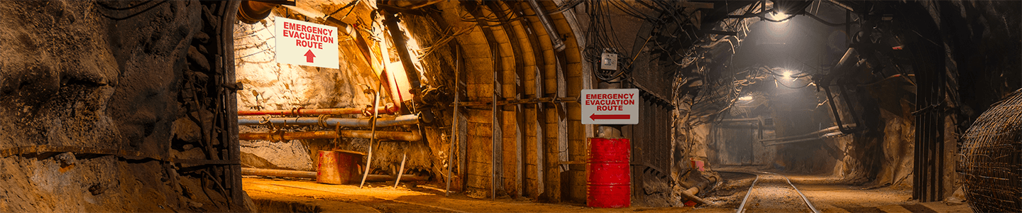  A well-lit mining tunnel with properly displayed OSHA-compliant signage  