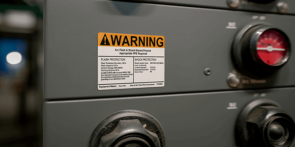Close-up of arc flash label showing voltage, PPE level, and boundary info