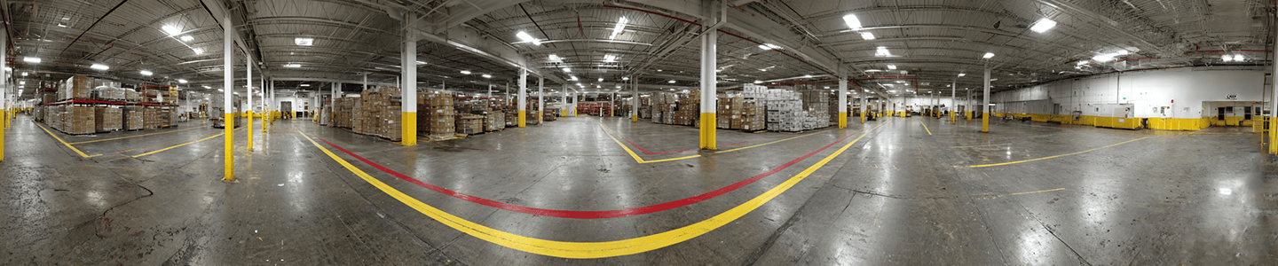 Close-up of floor marking tape under heavy traffic in an industrial facility.