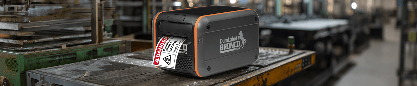 Bronco Max industrial label maker printing a danger label in a manufacturing environment.