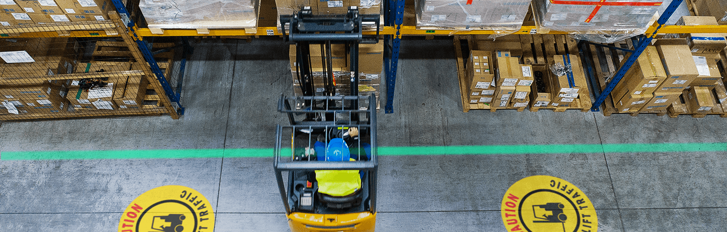 Forklift operating in a warehouse with LED floor marking to improve wayfinding