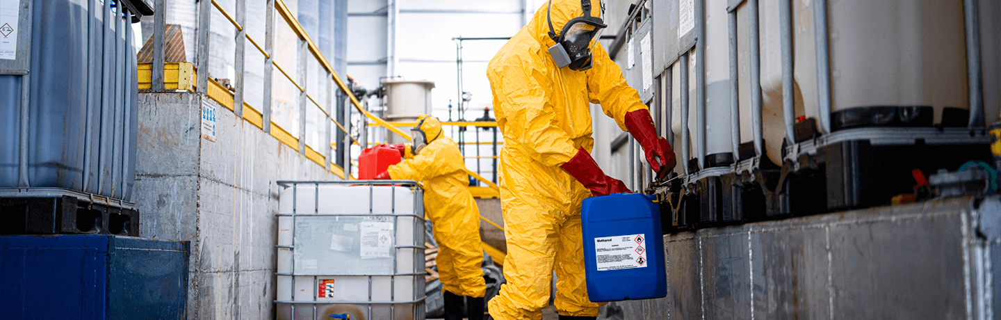 Workers handling chemical containers clearly marked with safety labels