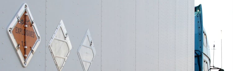 Explosives hazard placards displayed on a transport vehicle, indicating HazCom-compliant labeling for explosive materials during shipping and handling.