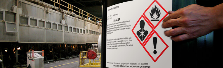 Industrial hazard label displaying pictograms for toxic and flammable substances in a safety-focused environment.