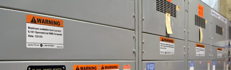 Warning labels on electrical panels for short circuit analysis, highlighting safety in industrial labeling solutions.