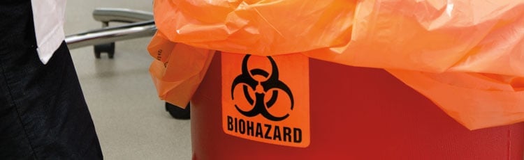 A biohazard waste bin with a compliant biohazard label