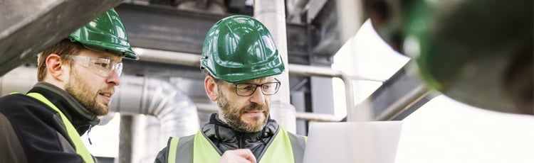 Two workers review a lean manufacturing checklist.