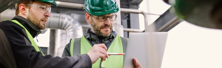 Workers in a warehouse examining a continuous improvement checklist.