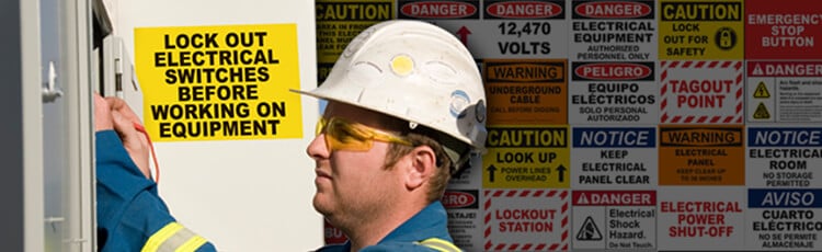 Worker in front of electrical safety signs printed from a thermal transfer printer