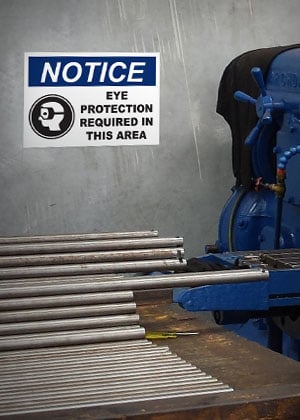 OSHA sign reminds workers to wear PPE.