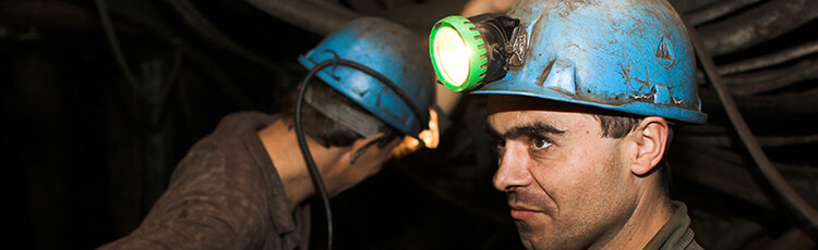 Two workers head down a mine shaft