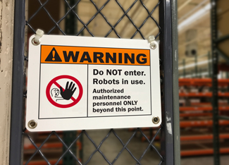 Sign warns of robots in use.