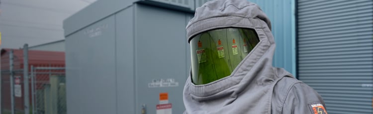 A worker in highly protective PPE about to work on electrical systems