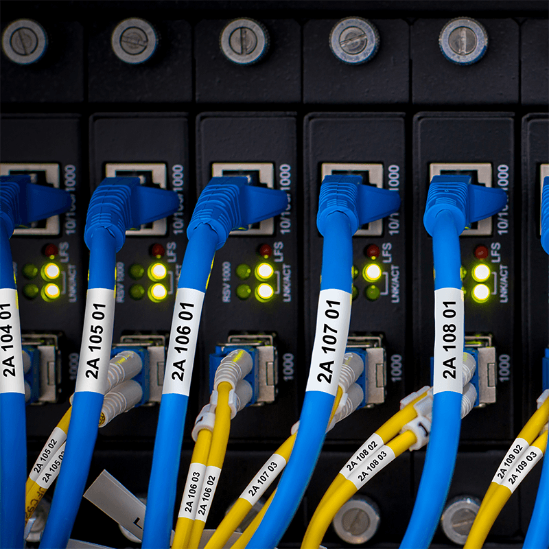 Labeled network cables connected to data center equipment and patch panels.