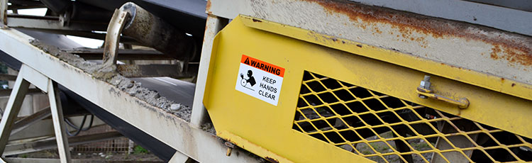 Machine guard with a warning sign